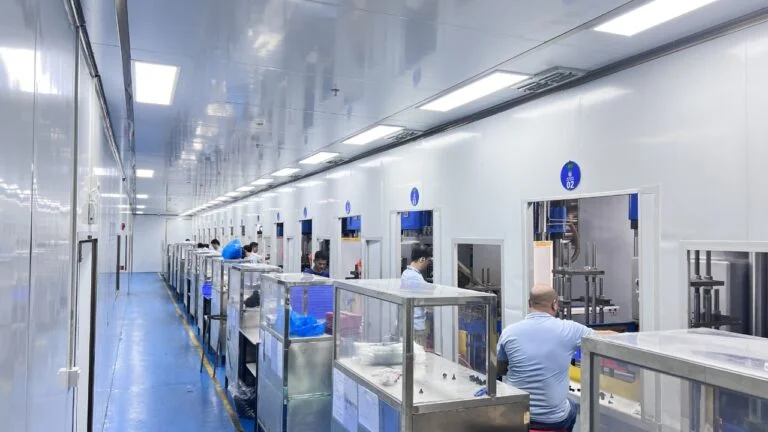 Workers operating injection molding machines in production workshop