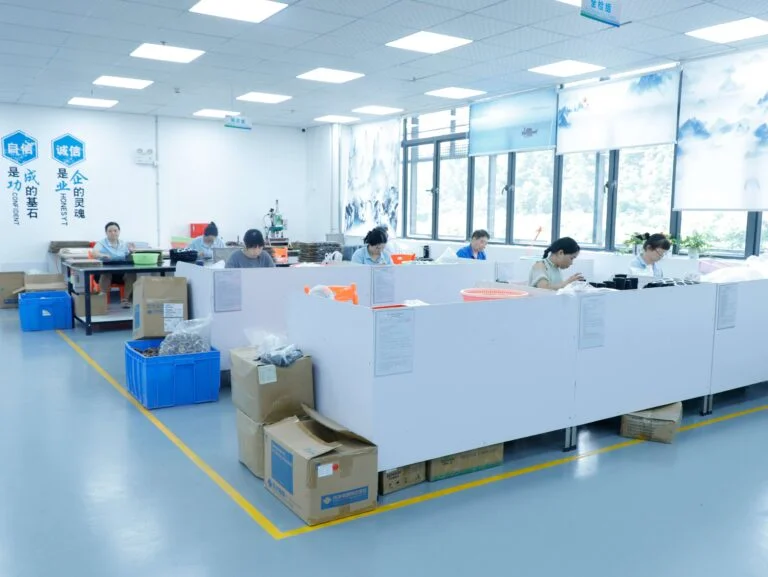 Workers operating injection molding machines in production workshop